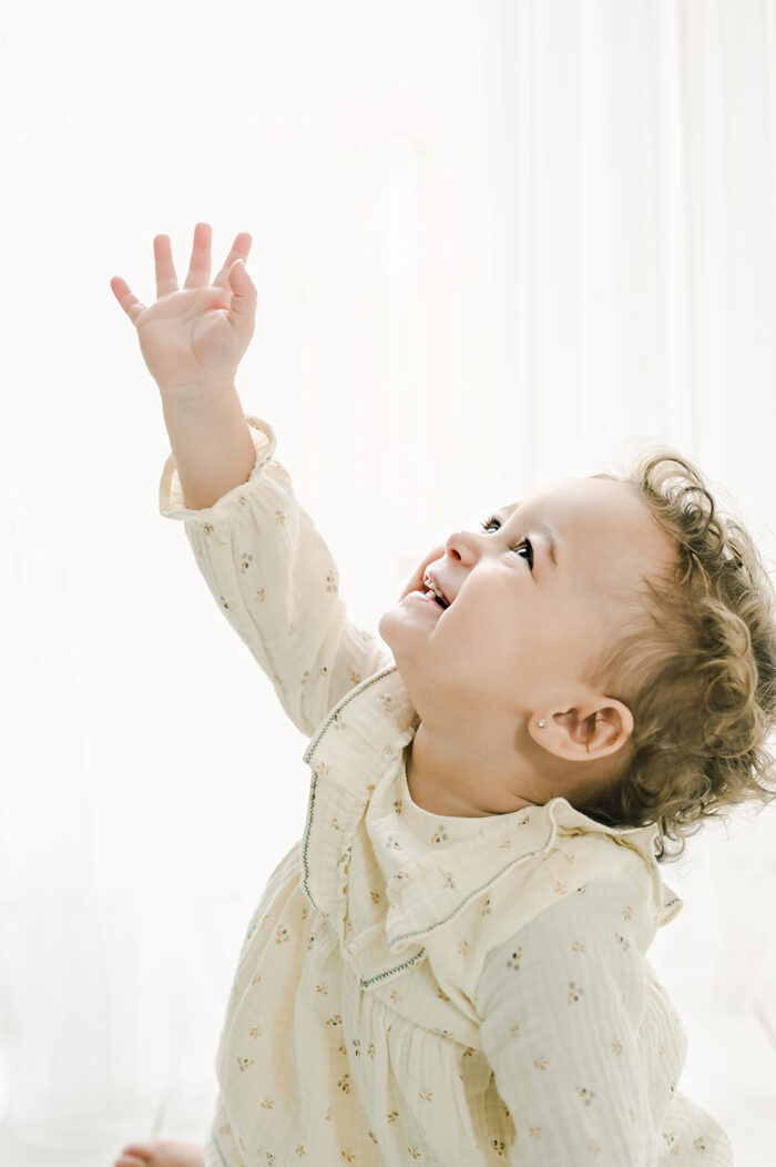 smiling baby girl in white studio space